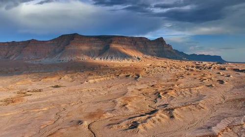 Stunning arid land and canyons. Drone flight over the desert and rocks under the grey sky.