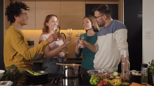 Friends Enjoying Wine While Cooking Together Indoors
