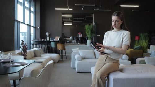 Elegant Woman Choosing Furniture From Catalog Showroom