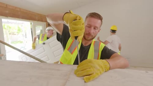 Construction Worker Uses Screwdriver Inside