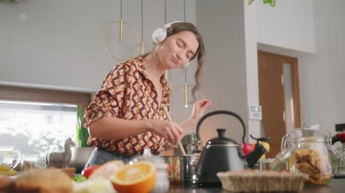 Woman Cooking and Listening to Music at Home