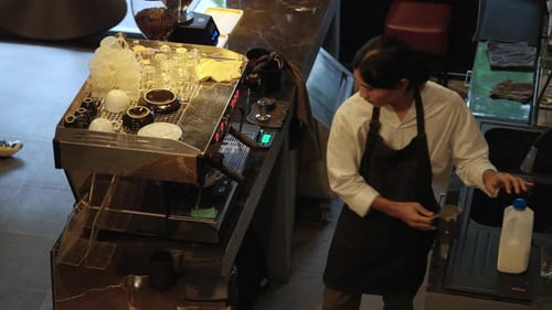 4K High angle view of Barista making hot coffee on coffee maker at coffee shop.