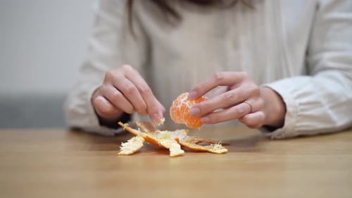 A woman who eats the white streaks of a mandarin orange