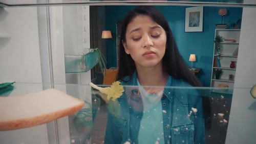 Young Woman Talking on Phone at Empty Refrigerator