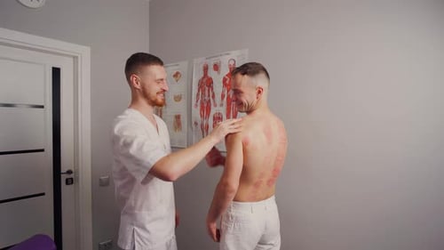 Therapist Treating Patient After Cupping in Clinic