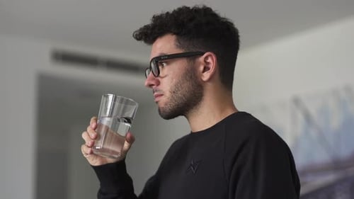 Kaukasischer Mann trinkt ein Glas Wasser