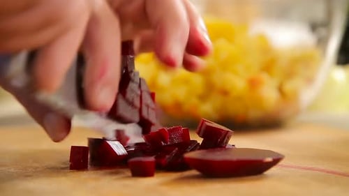 Gekochte Rote Beete auf einem Holzbrett schneiden