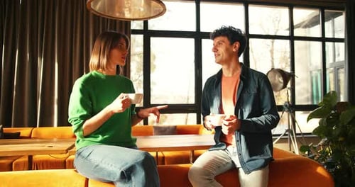 Young Couple Enjoying Coffee and Conversation in Stylish Cafe