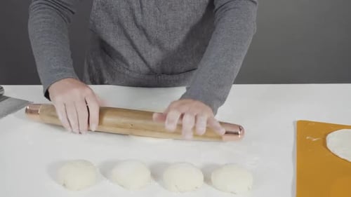 Woman Rolling Dough in Kitchen