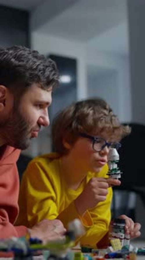 A Focused Child Wearing Glasses and a Yellow Shirt Builds and Assembles a Detailed Model Structure