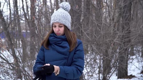 Young Woman Wearing Gloves in Winter Forest
