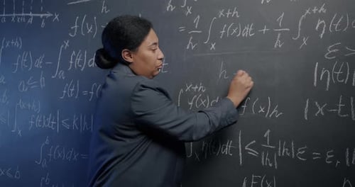 Woman Writing Math Equations on Chalkboard