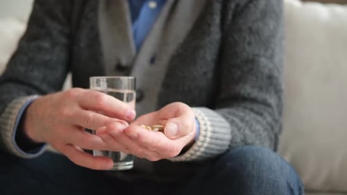 Adult Subject Holds Water and Pills Close Up