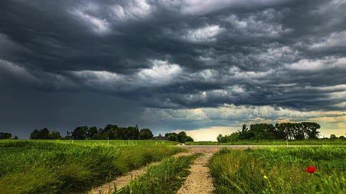 Stunning timelapse of grey cloud movement approaching a rain storm over a field and road