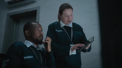 Security Team Monitoring Surveillance with Tablet and Radio