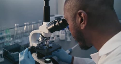 African American Scientist Analyzes Molecular Structure of Vaccine or Drug Under Microscope