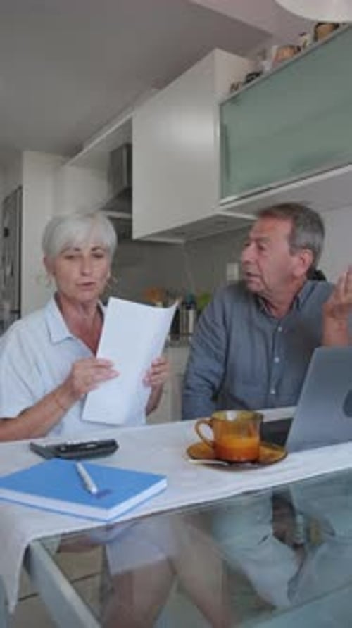 Senior Couple Discussing Documents at Home in Slow Motion