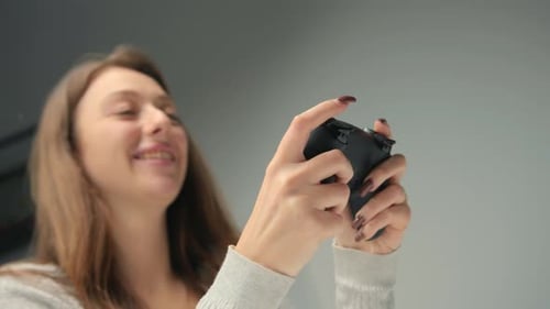 Close-up: A woman plays a console with a joystick or gamepad. Girl playing computer games
