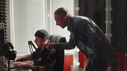 Deux hommes collaborant dans un studio avec équipement d'insonorisation et d'enregistrement
