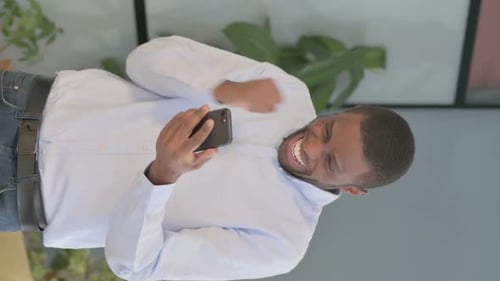 Young Adult Man Celebrating While Looking at Phone