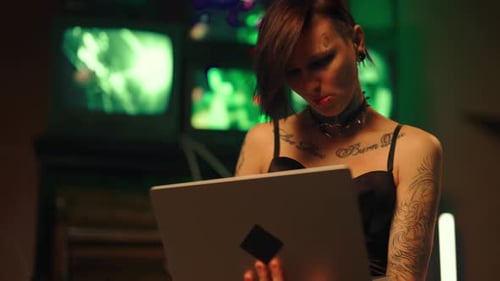 Sites Web de piratage informatique féminins talentueux par un puissant ordinateur portable dans la nuit, belle jeune femme