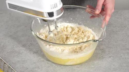 Step By Step Mixing Ingredients in a Glass Mixing Bowl to Prepare Lemon Cranberry Bundt Cake