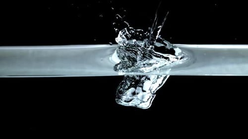 Water drop splashing into clean water, black background