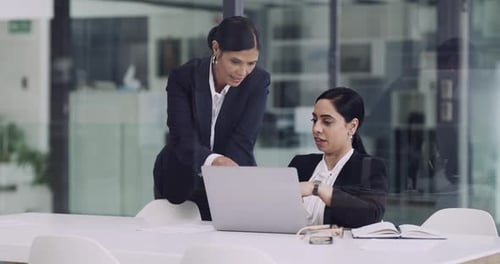 4k video footage of two businesswomen working together on a laptop in an office