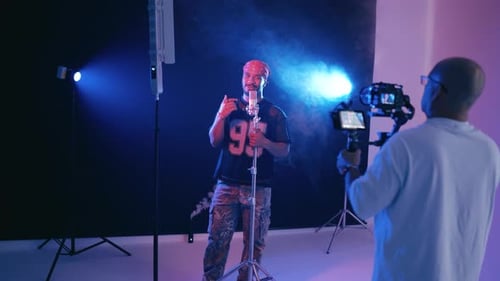 Man Singing into Microphone While Being Filmed