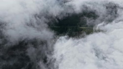 mountain road emerging through clouds