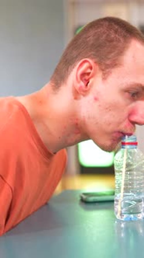 Man with Cerebral Palsy Drinking Water Helped By Straw