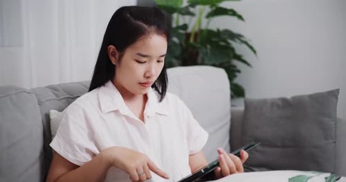 Woman Using Tablet on Couch Indoors