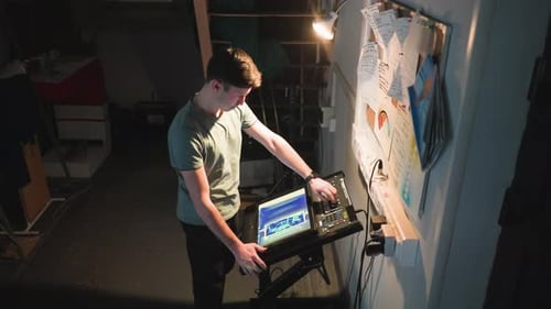 Technician Operating Control Panel in Dark Backstage Studio Environment