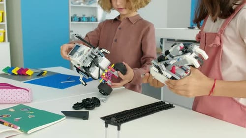 Preteen Boy and Girl Building Electric Toy Robots at Hobby Club