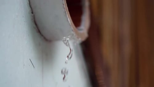 slow motion heavy rainfall flowing out drain pipe in wall during island tropical weather