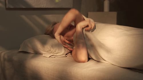 Woman Wakes Up and Stretches in Bed