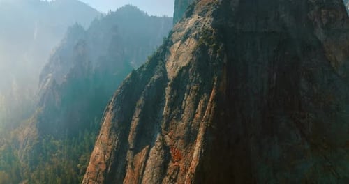 Sharp steep cliffs covered with thick white fog in Yosemite National Park, California, USA.