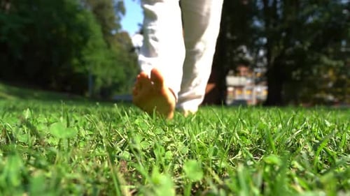 O homem anda descalço na natureza em câmera lenta. Sensação de liberdade e alegria.