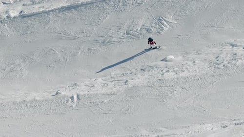 Ein Snowboarder, der auf der Extremwintersport-Skipiste eines Skigebiets am Berghang reitet Der Snowboarder