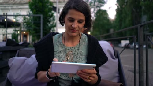 Young woman browsing on tablet in city cafe enjoying modern lifestyle