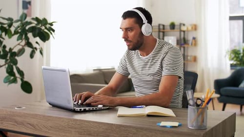 Man working on a laptop in bright home office