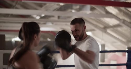 Woman Boxing with a Trainer in Boxing Ring