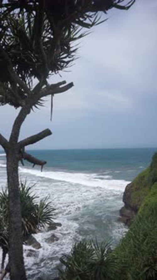 beautiful vertical video stretch of beach with blue sea water with big waves during the day