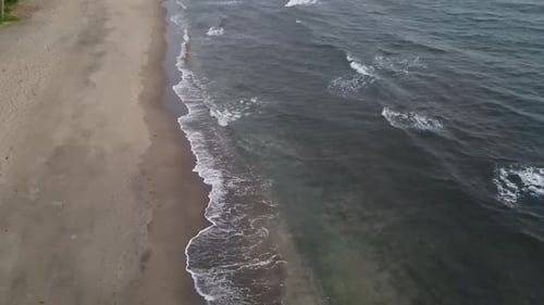 Aerial View of Sandy Beach Meeting the Ocean