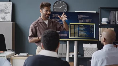 Indischer IT-Spezialist erklärt Kollegen Code auf dem Bildschirm