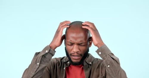 Stress, frustrated and anxiety of a man in studio with a headache, burnout or worry about mistake