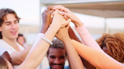 United Friends with Stacked Hands Raising Them Outdoors