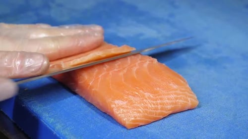 Chef Slices Salmon Fillet on Cutting Board
