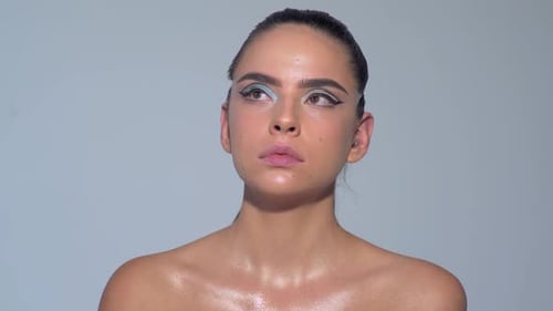 Visagistin trägt kosmetisches Gesicht auf, Hand des Make-up-Meisters, die Lippen junger Schönheit zu malen
