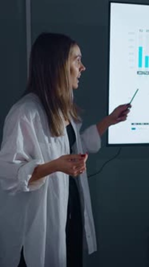 Confident Businesswoman Delivering Data Presentation in Modern Office Explaining Growth Charts and